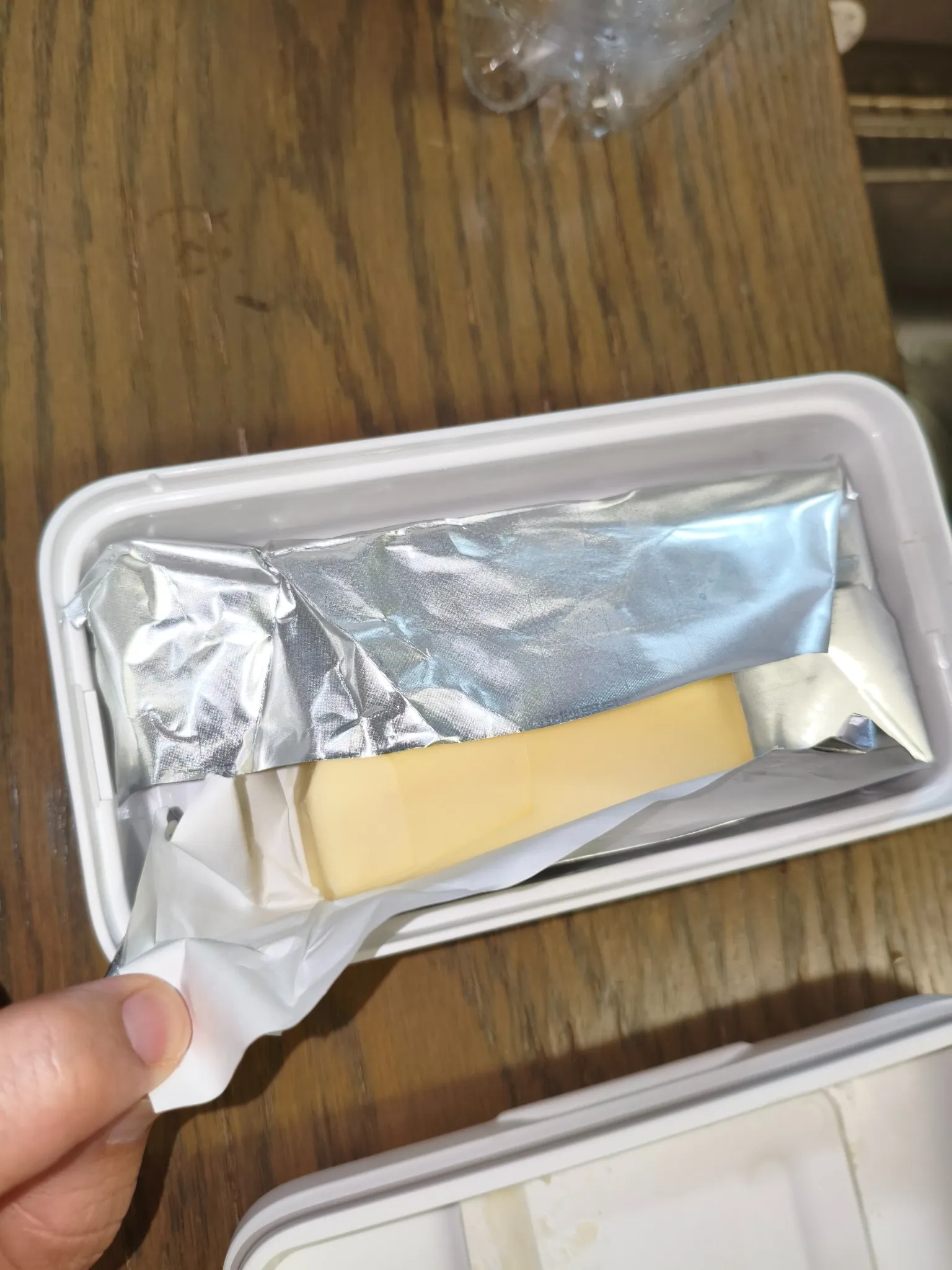 包装紙の一部を開き、白いケースの中のバターが見える状態