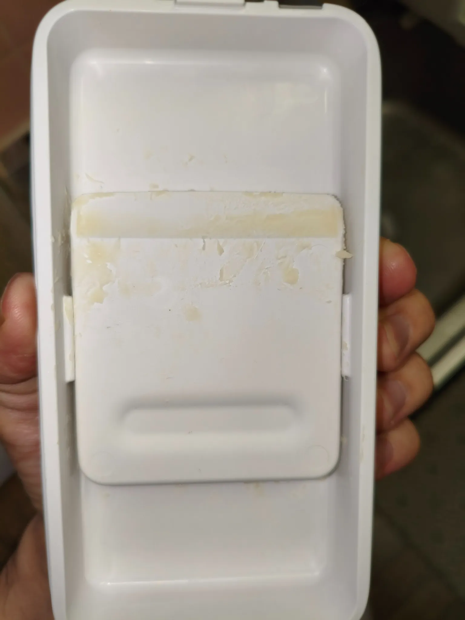 ふた内側に収納したカッターの面や縁、その周囲に黄色い付着が残っている写真