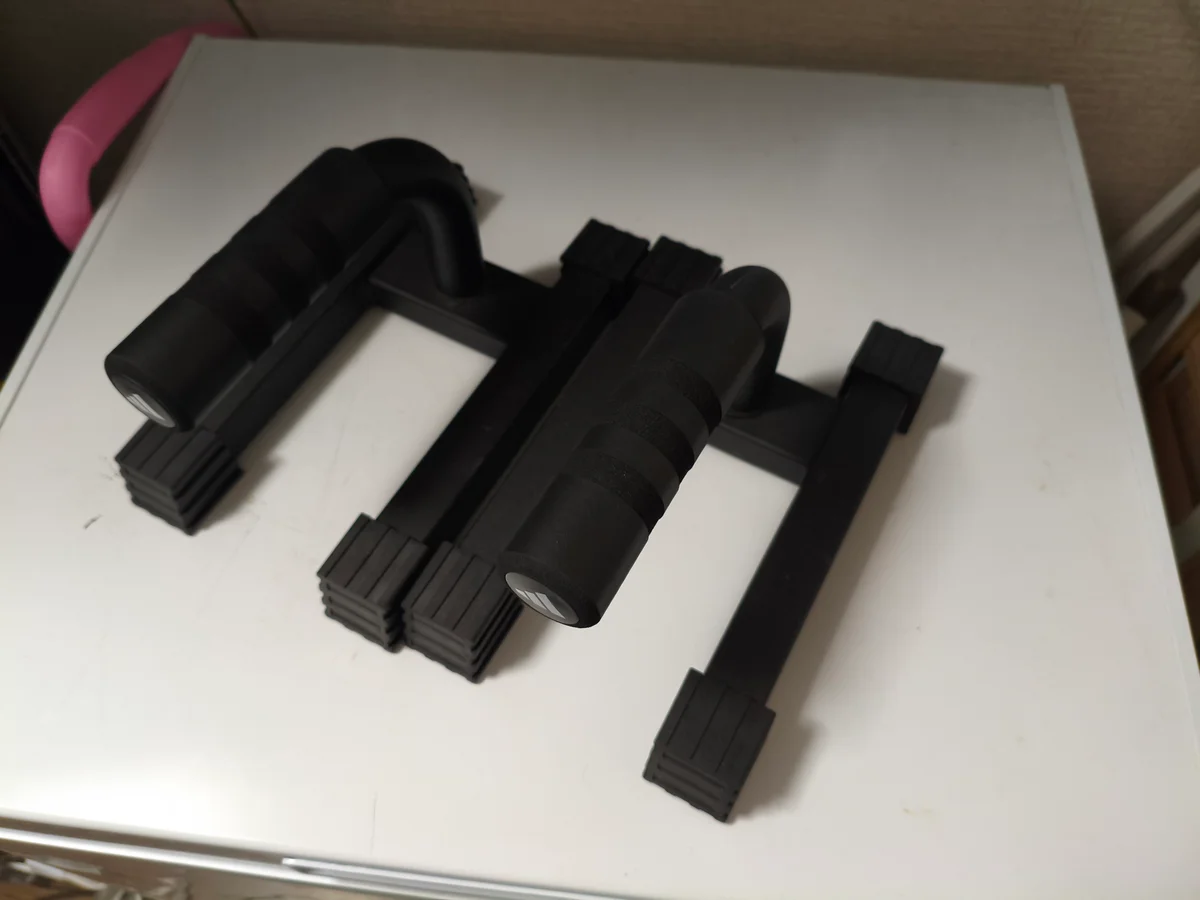 黒いグリップと横に広がる脚を備えた、使用者のプッシュアップバー2個