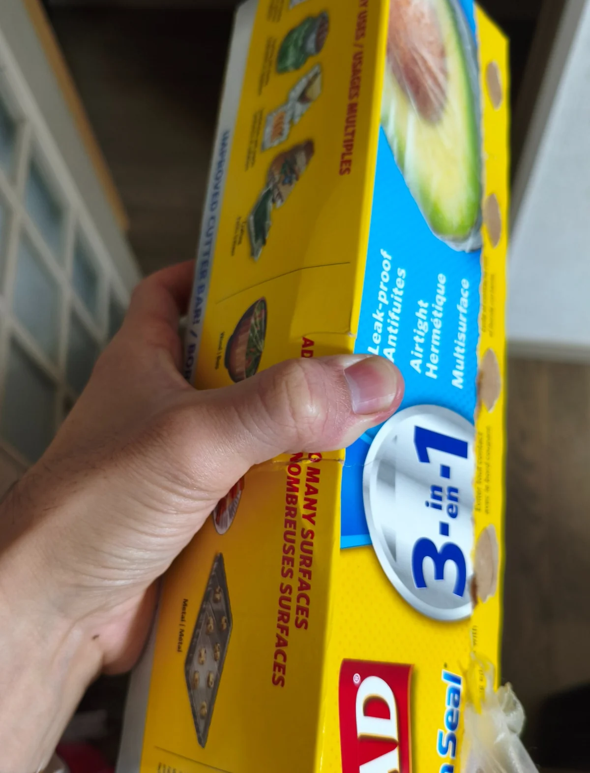 黄色いプレスンシールの大きな箱を手で持ったところ
